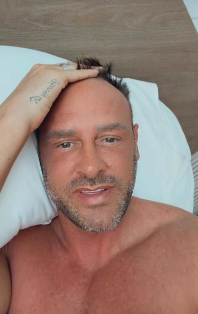 Lee, husband of Katie Price, looking at the camera with his hand on his head.