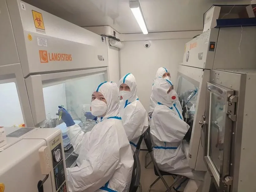 A team of Russia's Irkutsk anti-plague institute during laboratory work in full protective gear.