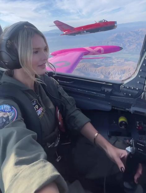 Kinsey Wolanski in a fighter jet cockpit with two other fighter jets flying outside.