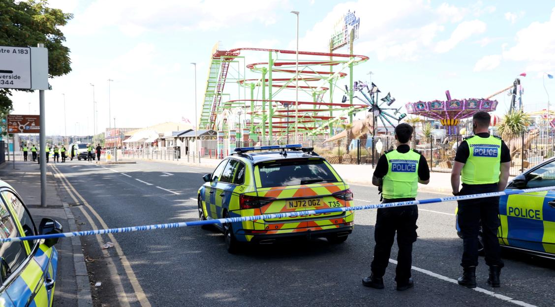 Police cordon at a road traffic incident near a fairground.