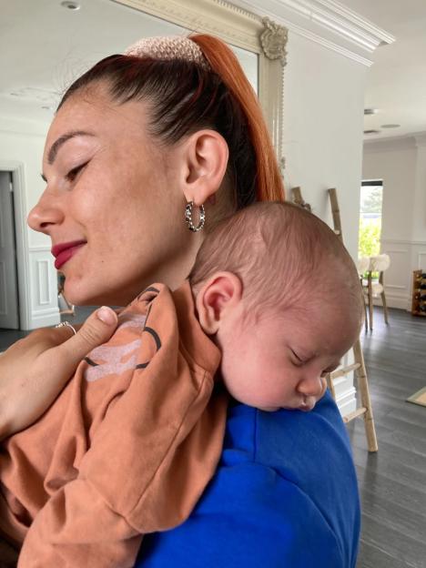 Dianne Buswell holding a sleeping baby.