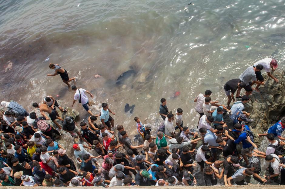 People walk on a beach as they attempt to cross from the Moroccan northern town of Fnideq to the Spanish enclave of Ceuta, Friday, July 31, 2026. (AP Photo) Copyright: AP:Associated Press