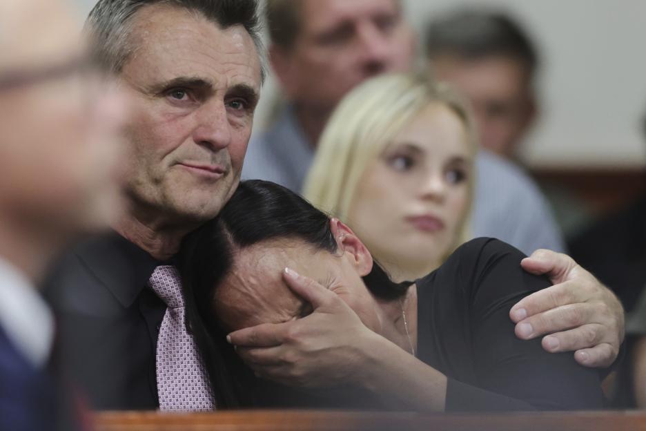 Cara Northington, mother of victim Xana Kernodle, cries into her hands while being comforted by a man at a sentencing hearing.