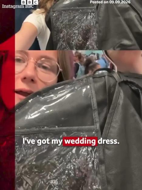 A woman holds her wedding dress in a garment bag at an airport while trying to get to her wedding.