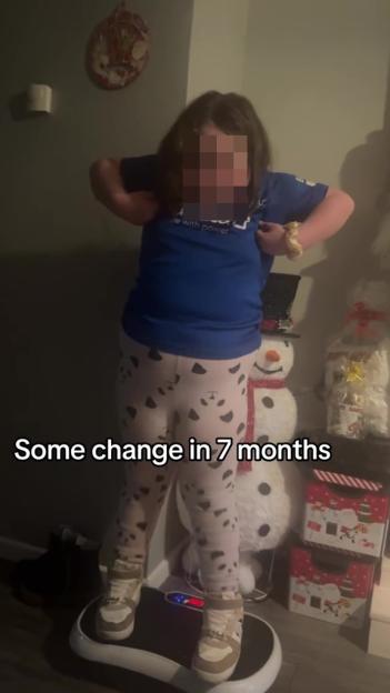 A young girl in a blue shirt and spotted pants stands on a scale in a room decorated for Christmas, with the text "Some change in 7 months."