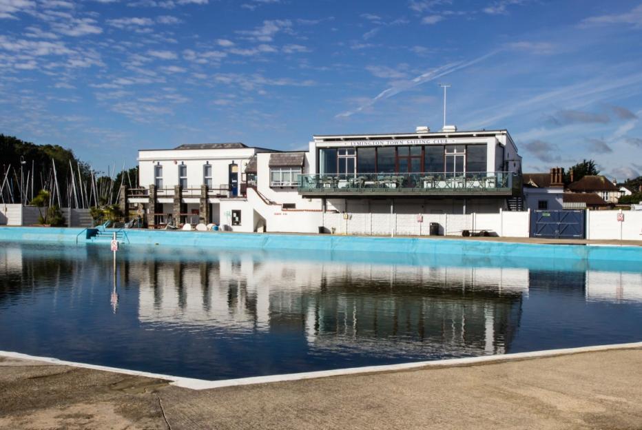 Lymington Town Sailing Club building reflected in the Lymington Sea Water Baths.