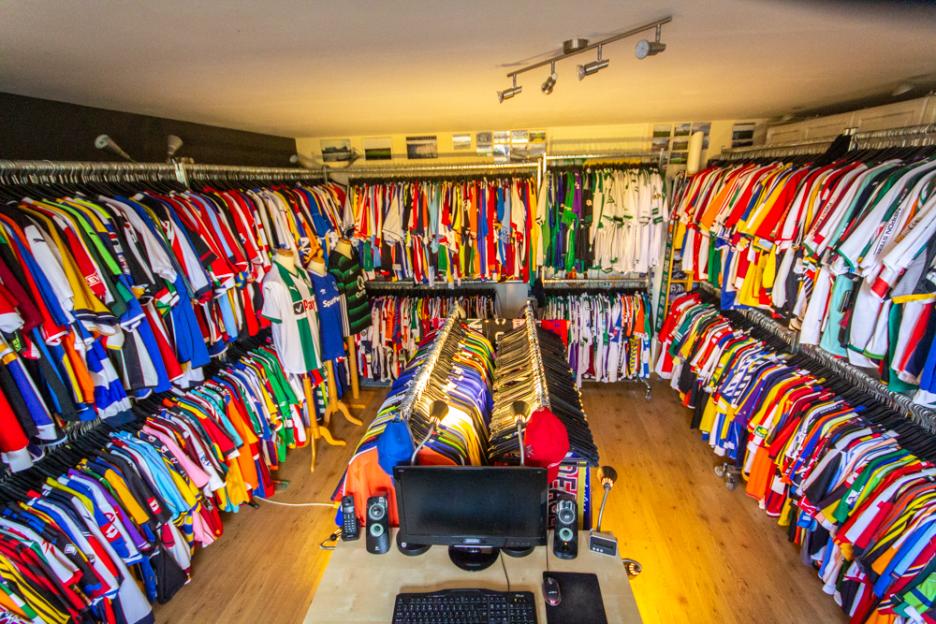 A room packed with soccer jerseys hanging on racks.