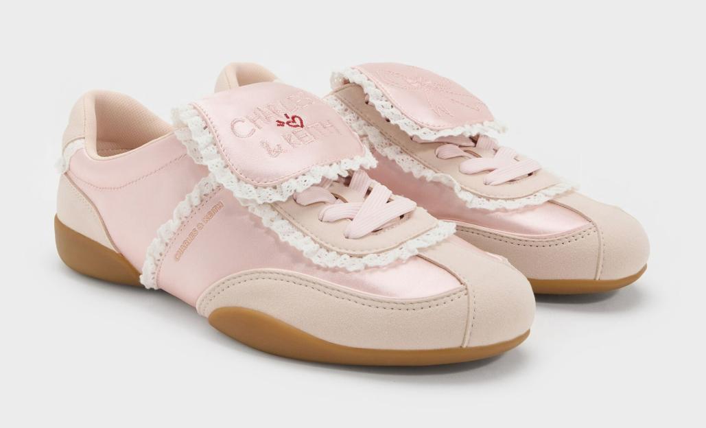 Pair of Charles & Keith pink sneakers with ruffles and beige accents.