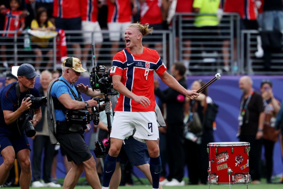 Norway's Haaland celebrates a goal with a drumstick in hand.