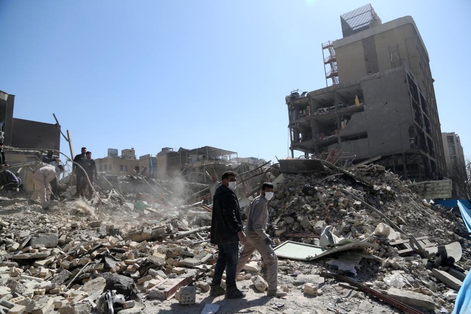 People walk through rubble and debris in Ferdowsi Square in Tehran after US and Israeli strikes.