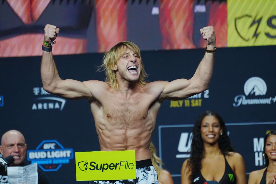 Paddy Pimblett at UFC 329 ceremonial weigh-ins, flexing his biceps with a yell.