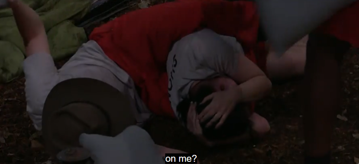 Shona and Aitch lying on the ground, with one wearing a hat.