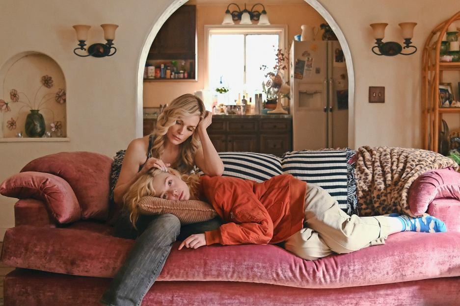Michelle Pfeiffer comforting Elle Fanning on a pink couch.