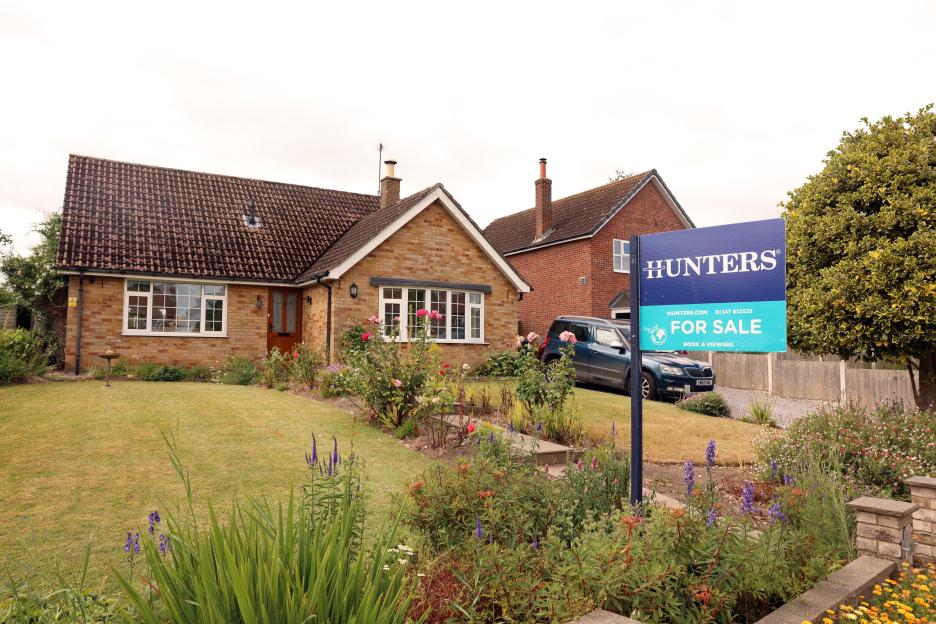 A house with a "FOR SALE" sign in its garden, where the sale has fallen through.