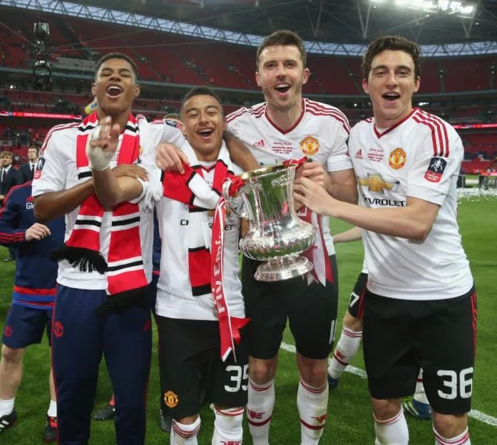 Manchester United players celebrate with the FA Cup trophy after winning the final.