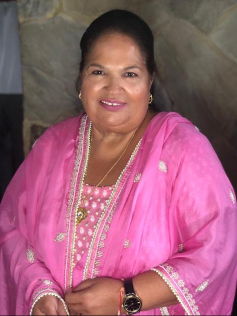 A smiling woman in a pink tunic and dupatta.