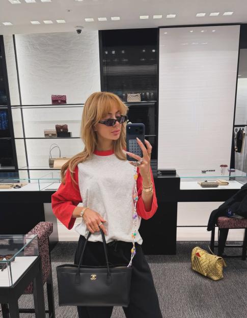 Olivia Attwood taking a mirror selfie while holding a black Chanel handbag.
