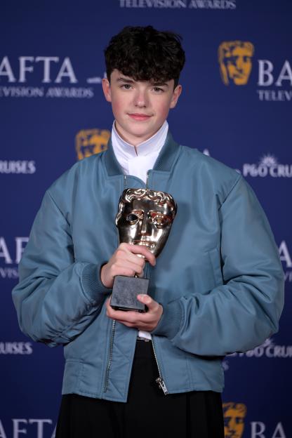 Owen Cooper holding his Supporting Actor Award for Adolescence at the 2026 BAFTA Television Awards.