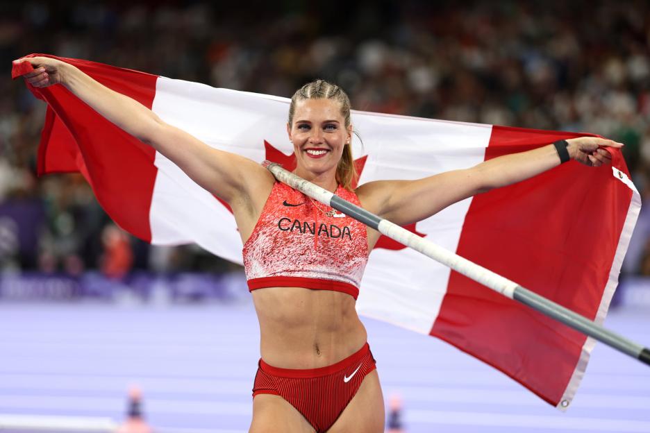 Pole vaulter Anicka Newell holding a Canadian flag.