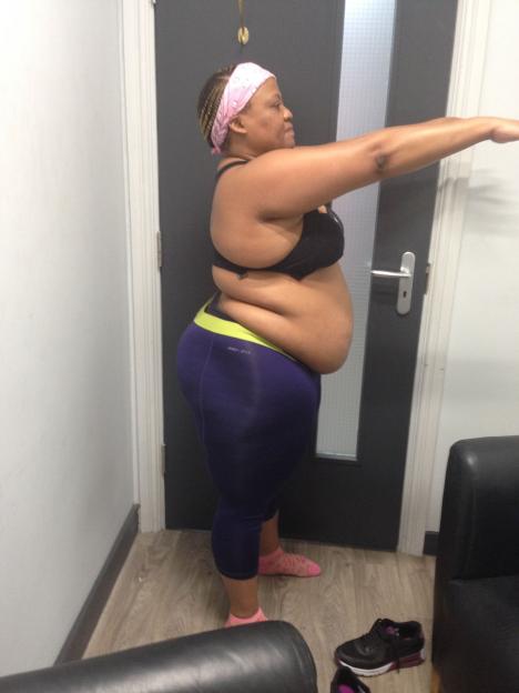 Charmaine Masoeu before weight loss, wearing a black sports bra and blue leggings.