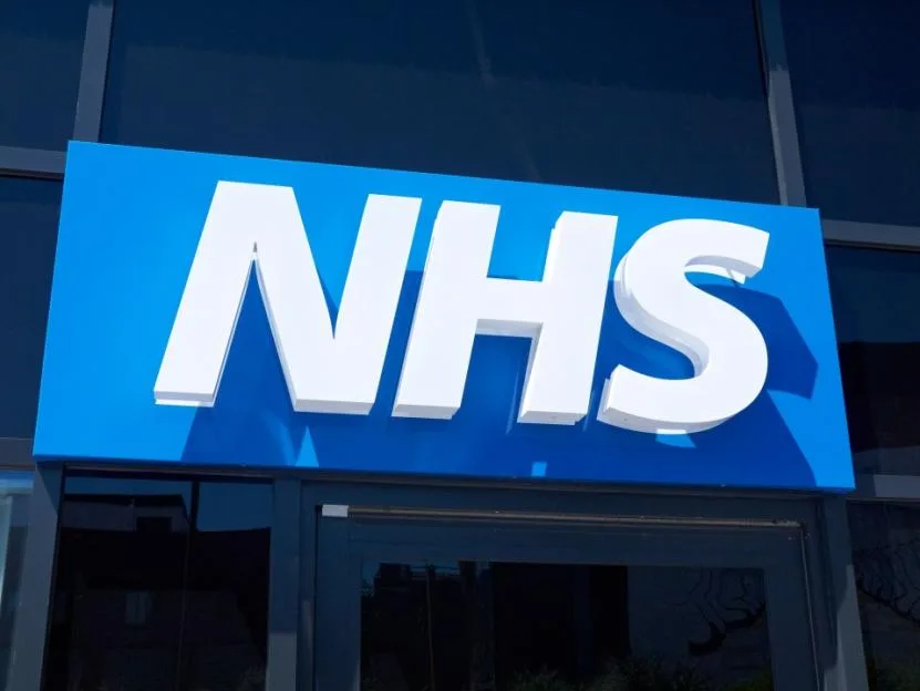 NHS logo on the outside wall of a building.