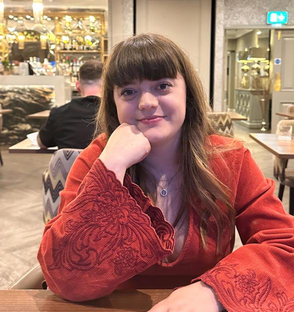 Travel reporter Cyann Fielding in a red outfit, sharing holiday savings tips.