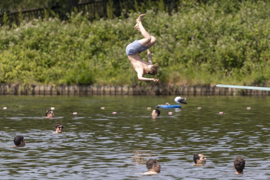 A swimmer jumps into the Hampstead Heath Pond in London.
