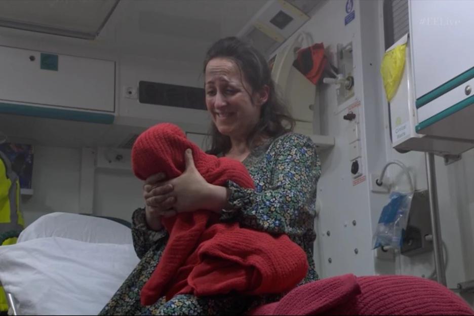 Natalie Cassidy as Sonia Fowler holding a baby in an ambulance.