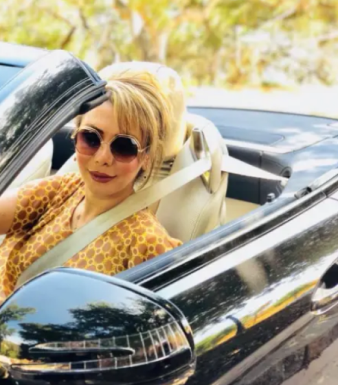 Iranian businesswoman Shamim Mafi wearing sunglasses in a convertible car.