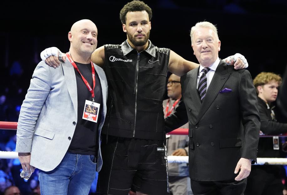 Moses Itauma (center) celebrating with Francis Warren and Frank Warren (right) after winning a WBA International and WBO Inter-Continental Heavyweight boxing bout.