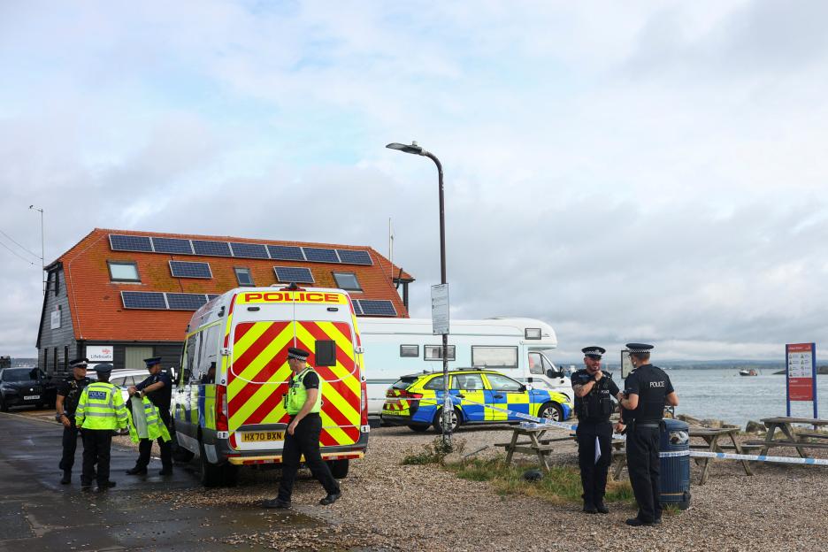 Police officers and vehicles stand near a building with solar panels by the water after anti-immigration protests in Portsmouth.