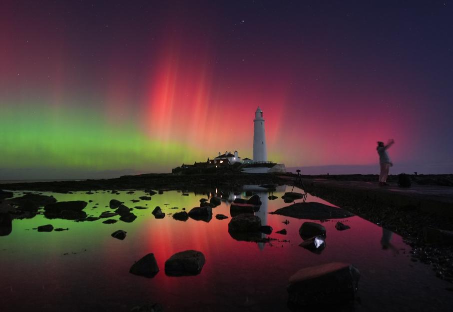The Northern Lights glow red and green over St Mary's Lighthouse in Whitley Bay.