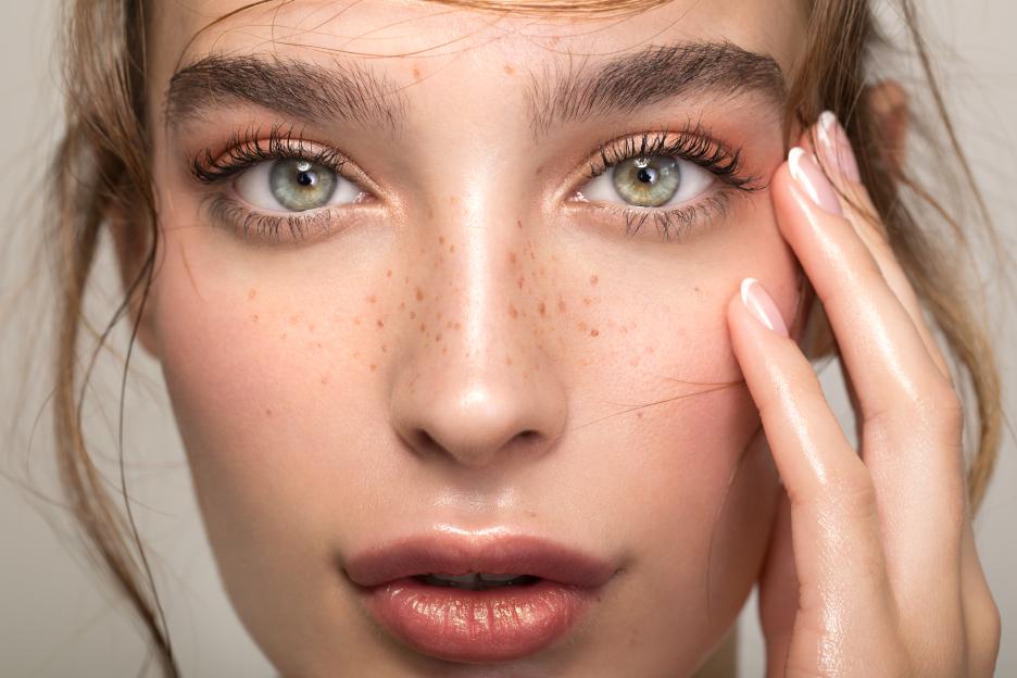 a close up of a woman 's face with freckles
