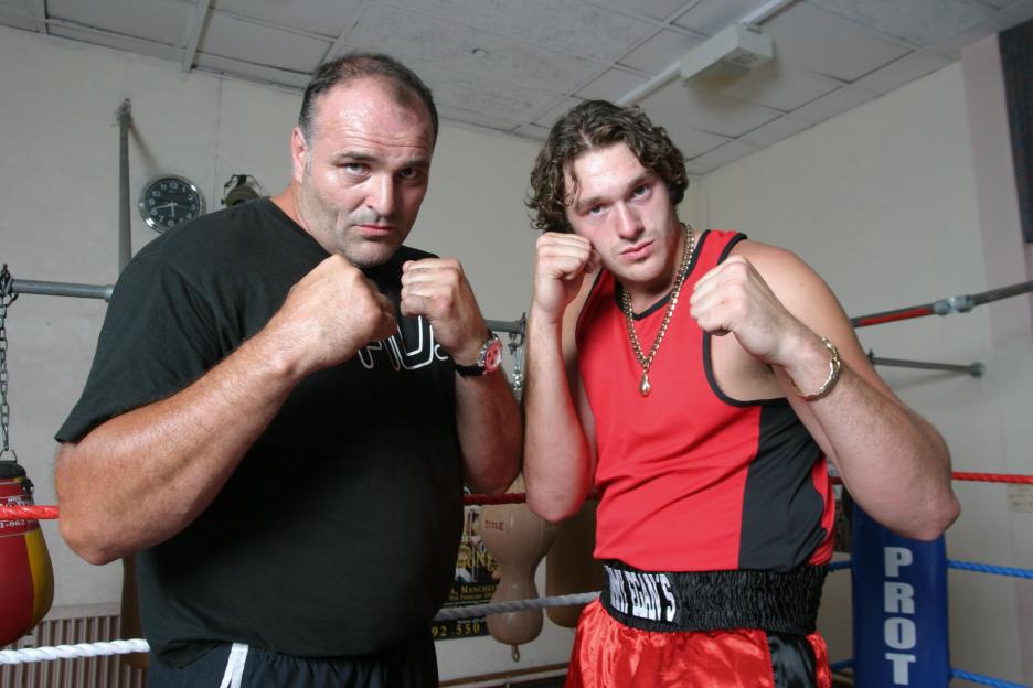 Tyson Fury and his father John Fury in boxing stances in a ring.