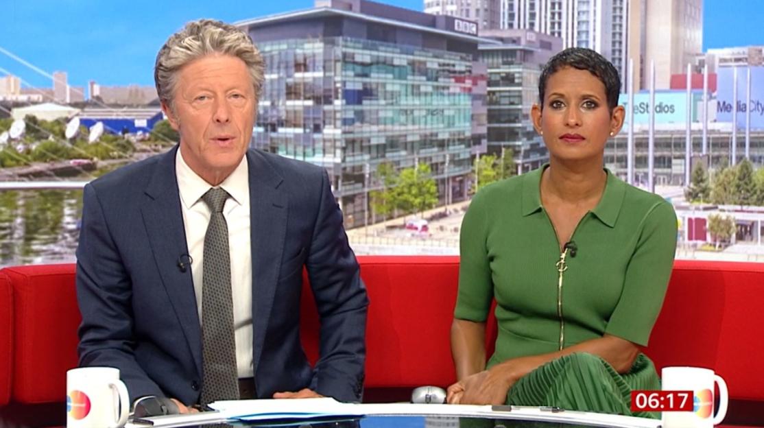 Two news anchors, a man and a woman, are seated at a news desk.