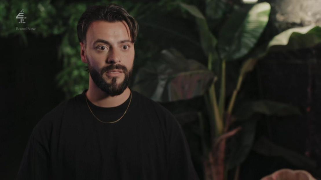 Davide looking surprised with wide eyes and an open mouth, surrounded by lush green foliage.