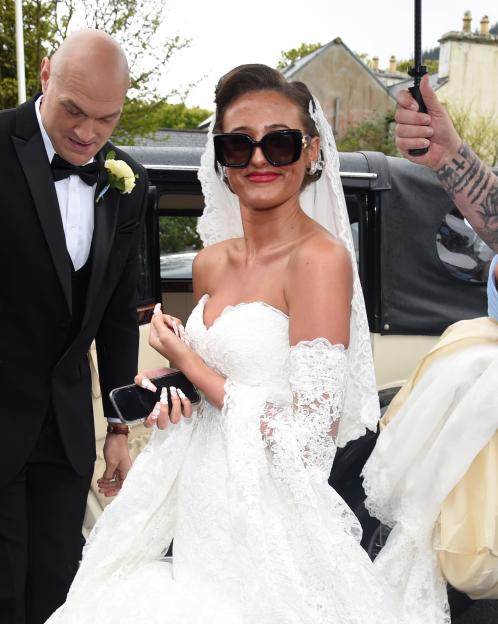 Venezuela Fury in a white lace wedding dress and sunglasses arriving for her wedding, with Tyson Fury beside her.