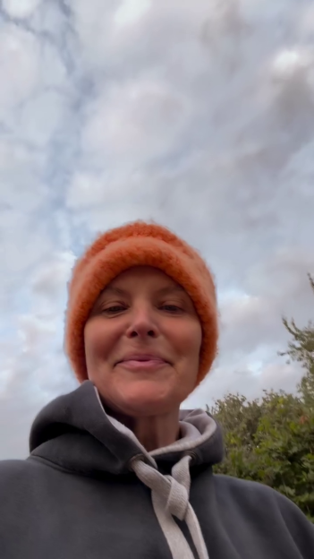 Tracy Shaw wearing an orange beanie and a gray hoodie.