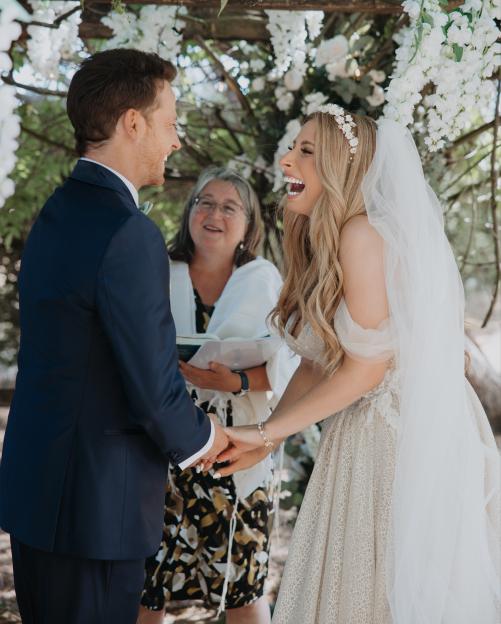Stacey Solomon and Joe Swash laughing and holding hands at their wedding ceremony.