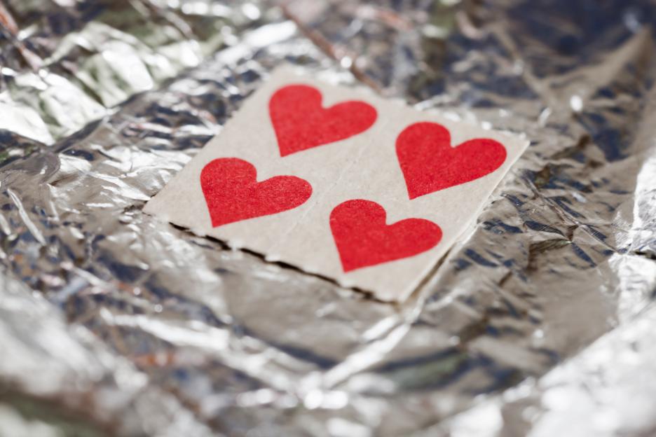 Four heart-shaped LSD blotters on crumpled aluminum foil.
