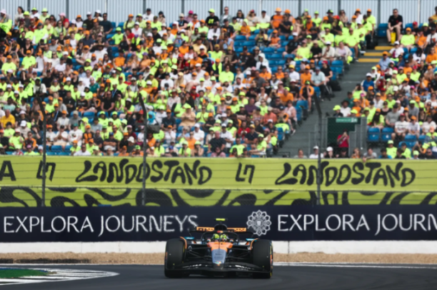 A Formula 1 race car on the track with a crowd in the background.