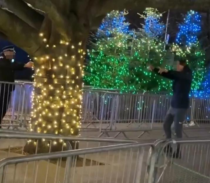 Young man raises arms as police approach with Taser