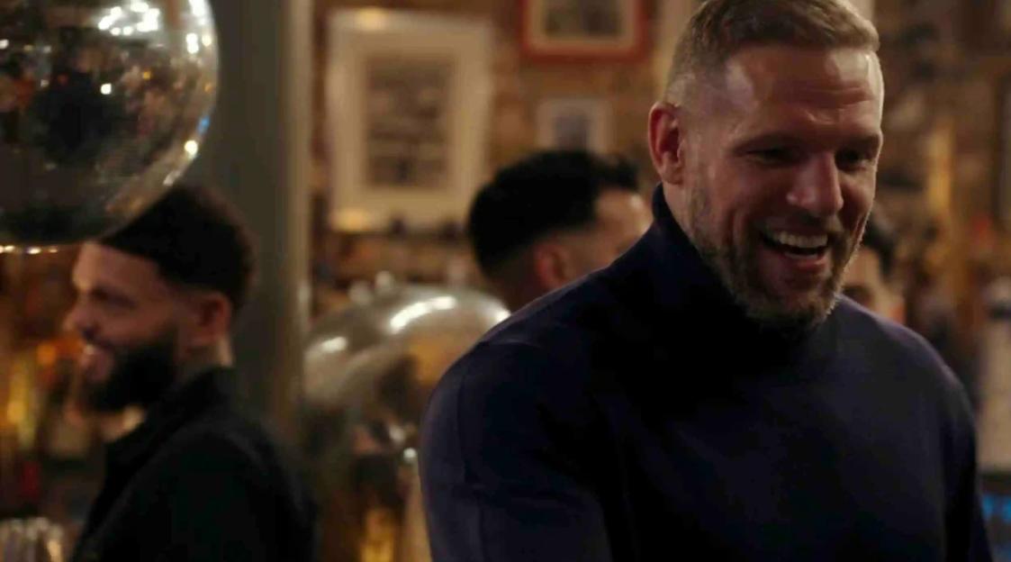 Smiling man in a dark turtleneck shirt from Celebs Go Dating.