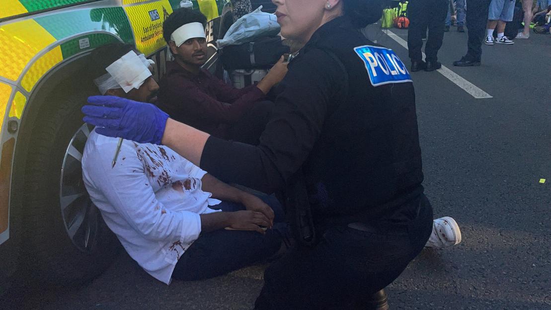 A police officer helps casualties after a train collision in Bedford, Britain.