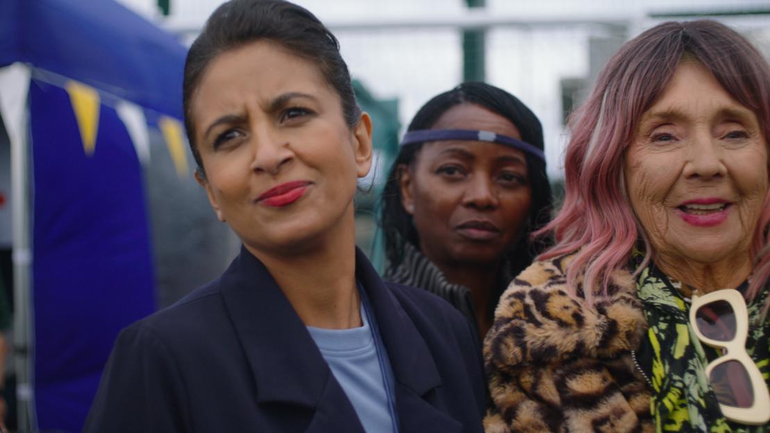 Konnie Huq, an older woman with pink hair, and another woman, standing outside.