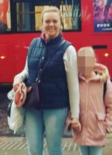 Nadiia Lavrynovych and Khristina stand in front of a red double-decker bus.