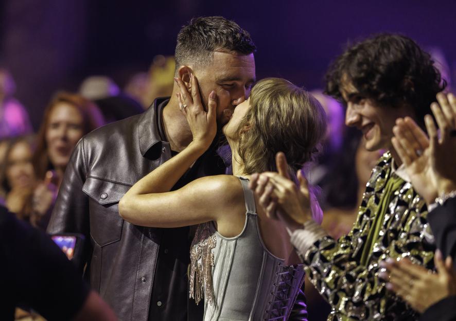 Taylor Swift and Travis Kelce kissing at the iHeartRadio Music Awards.