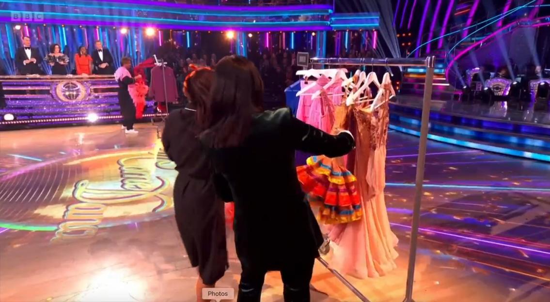 A live dance show featuring contestants in various dance costumes, with judges in the background.