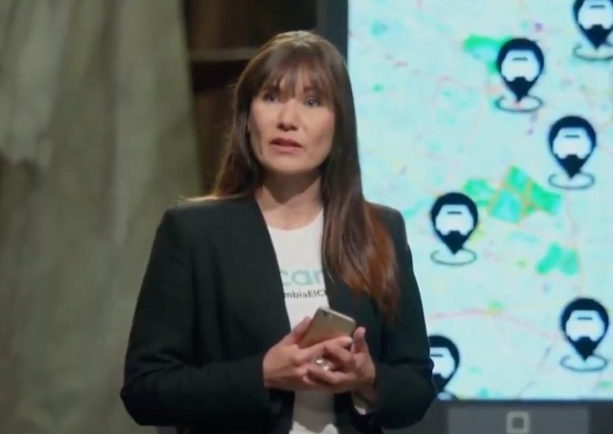 Zulma Guzman Castro holding a phone, with a map showing car icons in the background.