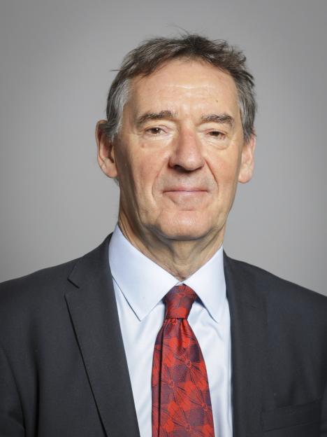 Headshot of Graham Stuart, a man with graying hair wearing a suit and red tie.